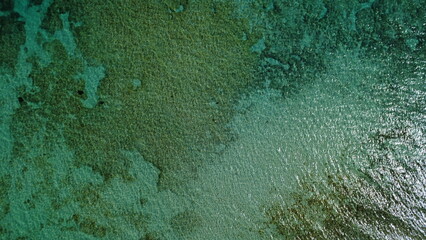  Aerial View of a Tranquil Turquoise Coastline with Rocky Cliffs and Sandy Beach