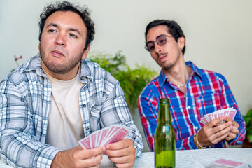 Friends playing cards and relaxing together at home