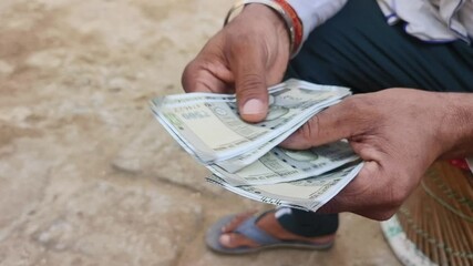 Counting 500 rupees Indian currency notes.	