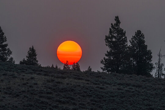 The morning sun rises over the hills and mountains that define Yellowstone NP.