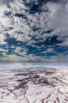 A light snowfall and contrasting orange-colored terrain define the rugged landscape of Canyonlands National Park.