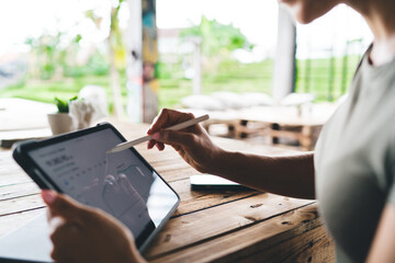 Freelancer using stylus on tablet to navigate crypto dashboard with price chart, working in eco-style location, focused on blockchain trends and digital investments