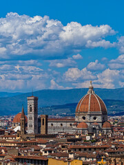 The dome of Santa Maria del Fiore dominates the Florence skyline, while the Church of San Lorenzo stands in the background, adding depth to the city's historic panorama.