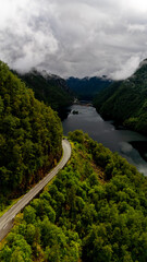 Breathtaking overview of a winding road along the serene fjord in Norways lush wilderness