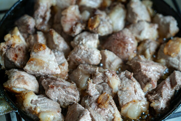 Juicy pieces of meat cooking in a skillet over medium heat