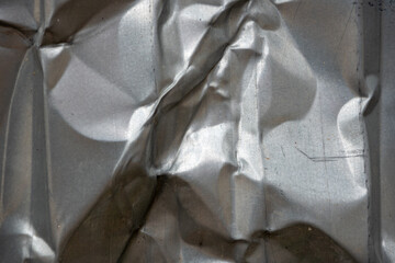 Crumpled metal surface reflecting light in unique patterns