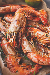 Juicy grilled shrimp, placed on a baking sheet lined with parchment paper, garnished with herbs and lemon.