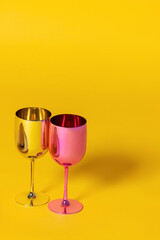 Two elegant champagne glasses with sparkling wine on a vibrant yellow background. Minimalist celebration concept with bright and festive mood. Toast, luxury, and celebration.