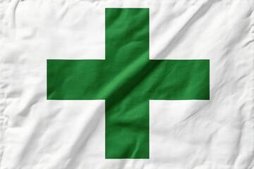 Green cross on white fabric background