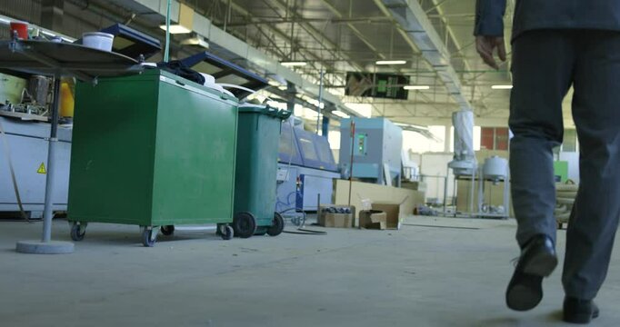 Businessman Walking Through Factory in Suit