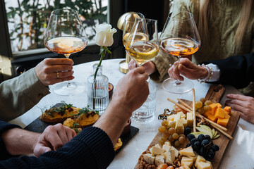 Friends having a dinner party with different kinds of appetizers and wine.