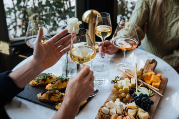 Friends having a dinner party with different kinds of appetizers and wine.