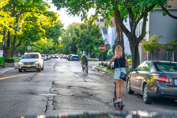 Girl riding a scooter along the city streets