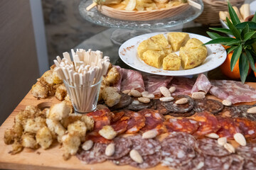 Traditional wooden board with assorted Italian cured meats and salami ready to serve