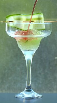 Botanical infused cocktail pouring into ice