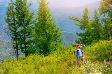 Young caucasian male hiker with backpack enjoying beautiful mountain view in Altay, Russia