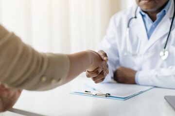 Medical Services Concept. Doctor Man And Female Patient Handshaking During Meeting In Clinic, Black...
