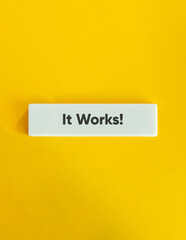 It Works Text on Block Letter Tile on Yellow Background. Minimal Aesthetic.