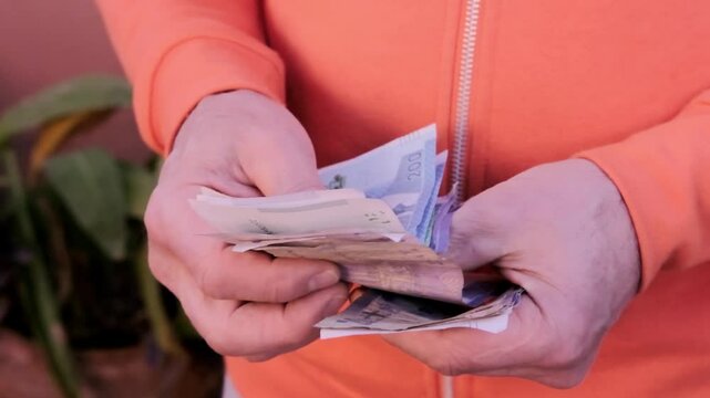 closeup male hands hold Moroccan dirham money, count paper dirham banknotes, concept cash payments, monetary savings, save for vacation, exchange and cashing currency