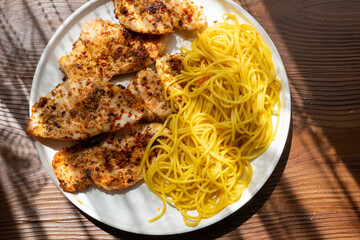 Close-up of fried chicken and spaghetti pasta Italian style restaurant presentation