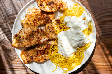 Close-up of fried chicken and spaghetti pasta Italian style restaurant presentation