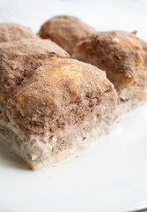 Cold baklava with cacao on a white plate	close up
