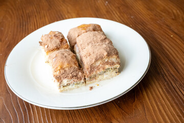 Cold baklava with cacao on a white plate	close up