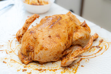 Whole chicken marinated with spices ready for cooking in a kitchen setting
