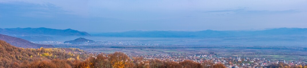 mountain landscape in fog and autumn trees panorama