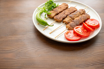 Close-up of traditional Turkish shish kebabs on oval plate