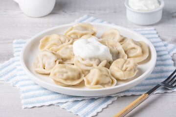 Traditional pelmeni, ravioli, dumplings filled with meat on plate, russian kitchen.