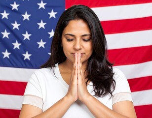 Young black woman praying with united states flag in background
