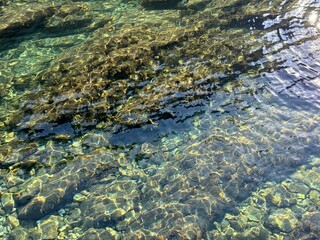 Crystal-clear sea water with underwater stones and pebbles. 