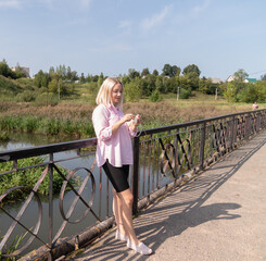 A happy smiling young woman knits on the street. Knitting Day in public