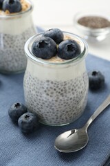 Delicious pudding with chia seeds, yogurt, blueberries and granola on white table, closeup. Superfood