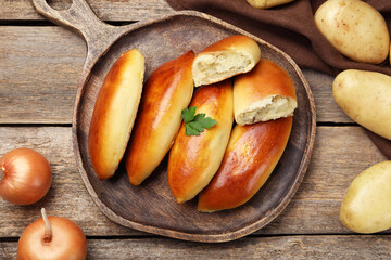 Tasty baked patties with potato and parsley on wooden table, flat lay