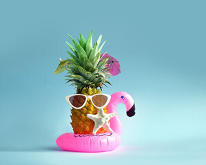 Pink inflatable flamingo and pineapple in sunglasses. Summer pool float party idea. Summer concept.