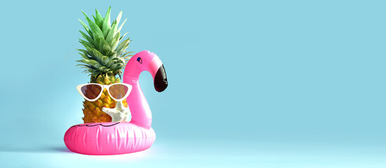 Pink inflatable flamingo and pineapple in sunglasses. Summer pool float party idea. Summer concept.