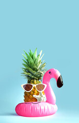 Pink inflatable flamingo and pineapple in sunglasses. Summer pool float party idea. Summer concept.
