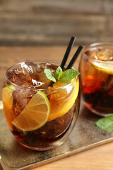 Refreshing Cuba libre cocktail with mint on wooden table, closeup