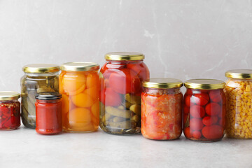 Many jars with different pickled products on light table