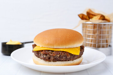 Cheeseburger with tasty patty on white table, closeup