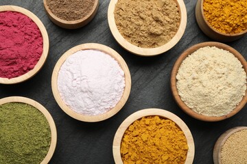 Different superfood powders on black table, flat lay
