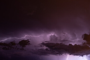 Lightning dancing in the sky on a cloudy night. Dark clouds and lightning in the fantasy sky. Clouds discharge their electrical charge.
