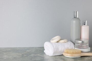 Different bath accessories on grey marble table, closeup. Space for text