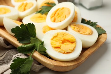 Boiled eggs and parsley on white table, closeup
