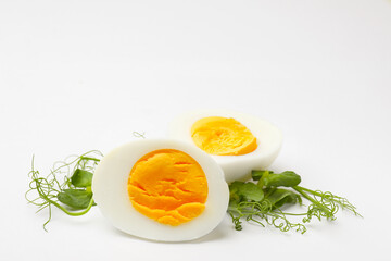 Boiled egg and microgreens on white background