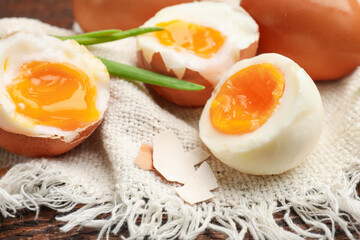 Soft boiled eggs with green onions on wooden table, closeup