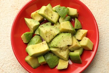 Tasty cut avocados with dressing on light textured table, top view
