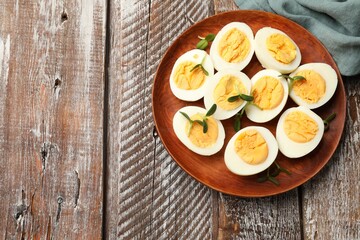 Hard boiled eggs with microgreens on wooden table, top view. Space for text